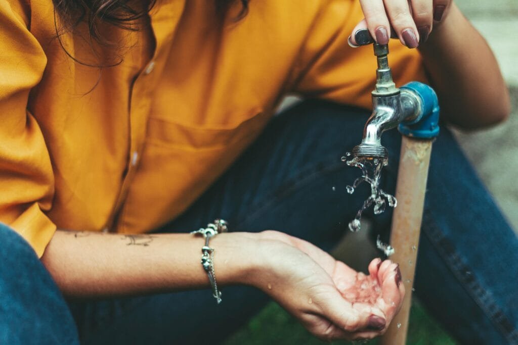 Person Opening Faucet And Washing Own Hands